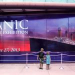 Children stand in front of Titanic exhibition banner wall