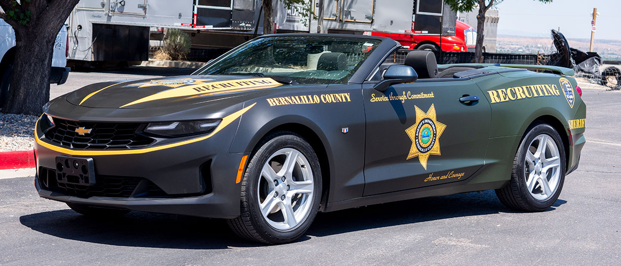 Bernalillo Sheriff wanted a matching set of recruiting vehicles, so they took a convertible Camaro and an Explorer and wrapped them with a satin OD Green gradient with yellow highlights. They certainly get noticed when they show up on the scene!